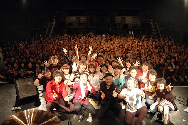 怒髪天メンバーと臨時記者、会場の全員で記念撮影。記者の中には親子2代の怒髪天ファンも。Twitter上では、最後に握手で見送られた幸運な記者たちに対し「うらやましい！」という声が上がった。