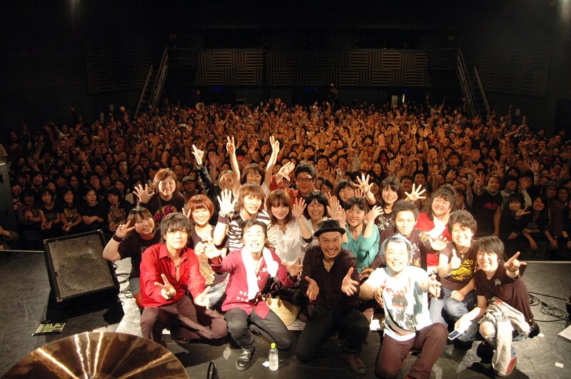 怒髪天メンバーと臨時記者、会場の全員で記念撮影。記者の中には親子2代の怒髪天ファンも。Twitter上では、最後に握手で見送られた幸運な記者たちに対し「うらやましい!」という声が上がった。