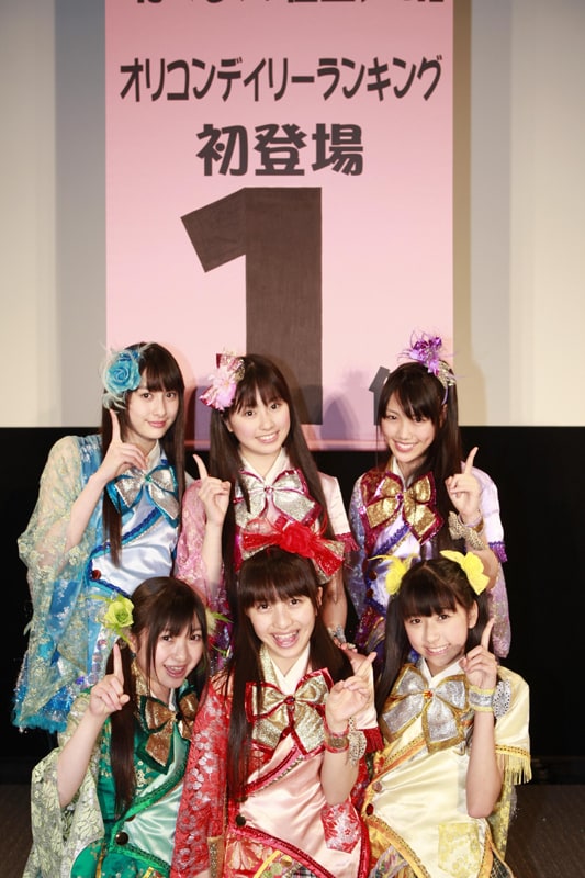 オリコンデイリーチャート1位を告げるサプライズ垂れ幕をバックに記念撮影。
