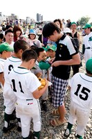 隣のグラウンドで野球をしていた少年たちにサインをするふかわ。