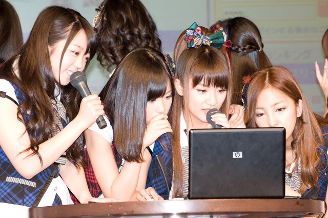 PC画面に映し出される情報のひとつひとつに、驚いた表情を見せるAKB48のメンバー。写真左から峯岸みなみ、前田敦子、高橋みなみ、板野友美。