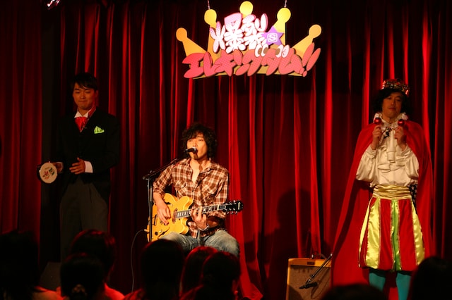 弾き語りを披露する斉藤和義（写真中央）と、タンバリンを叩く今立進（左）、マラカスを振るやついいちろう（右）。