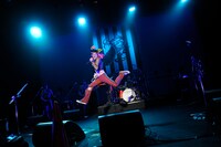 「ともかず ～バイト君40歳記念ソング～」を歌いながら、高らかにジャンプを決めるバイト君。パンク精神あふれる衣装が眩しい（photo by Toshikazu Oguruma）。