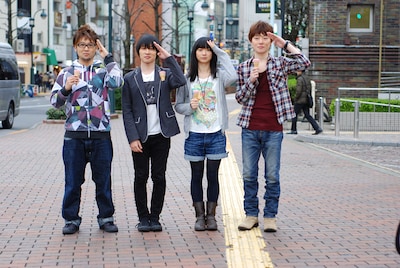 渋谷の街中で敬礼するBase Ball Bearの4人。メンバーが手にしているのはカプリコ。