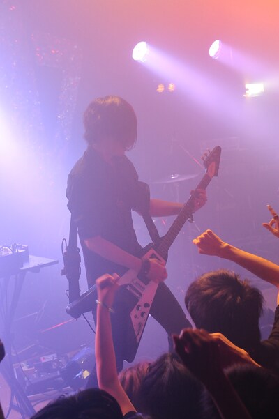 ステージ前方に出てアグレッシブなプレイを見せる中野。ライブ終了後には前方の観客と握手を交わすサービスも。