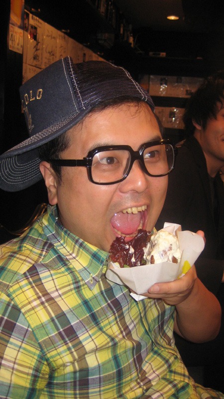 特製肉巻きおにぎり「リアルとろ巻き」にかぶりつく、とろサーモン久保田和靖