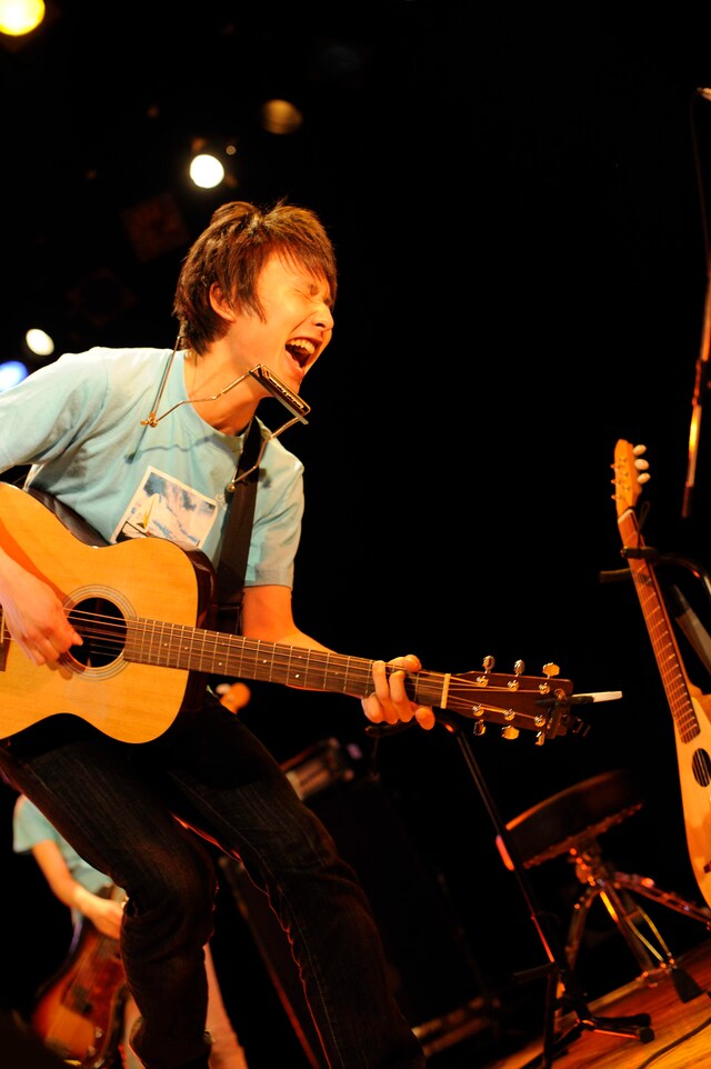 「アイス缶珈琲」のビデオクリップでサラリーマンに扮しているsuzumoku。所属レーベルWorld apartのオフィシャルYouTubeチャンネルでは、ビデオクリップをフルサイズで公開している。