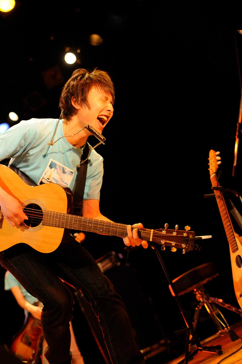 「アイス缶珈琲」のビデオクリップでサラリーマンに扮しているsuzumoku。所属レーベルWorld apartのオフィシャルYouTubeチャンネルでは、ビデオクリップをフルサイズで公開している。