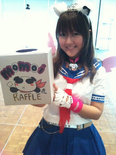 「momoi quest」スタンプラリーで使用された手作りのクジ引き箱を持つモモーイ。