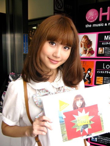 8月いっぱいで閉店することが決定したHMV渋谷前。Mayが持っているのはアルバム「Re;未来派宣言」通常盤ジャケット。