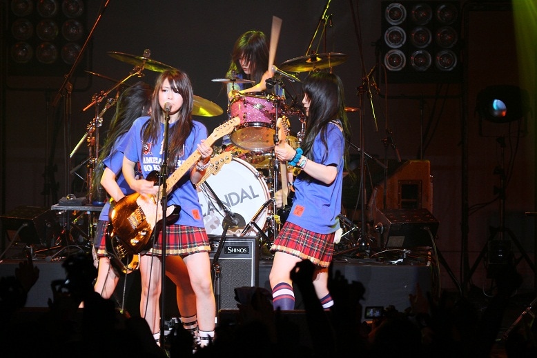 写真はSHIBUYA-AX公演のアンコールの模様。メンバーはサッカー日本代表ユニフォームを模したSCANDALオリジナルTシャツを着て再登場。当日の夜にはワールドカップ日本代表の1戦目があり、熱い気持ちをそのまま日本代表選手に届けるようなパフォーマンスを披露した。