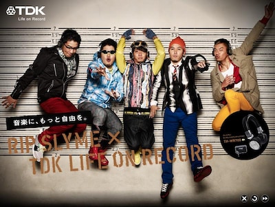 今回の広告ビジュアルでは、留置所に捕われたRIP SLYMEが「プレミアム・ワイヤレス ステレオヘッドホン TH-WR700」で音楽を自由に楽しんでいる様子を表現。