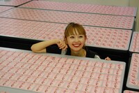 並べられたトレーディングカードを前に微笑むMizca。