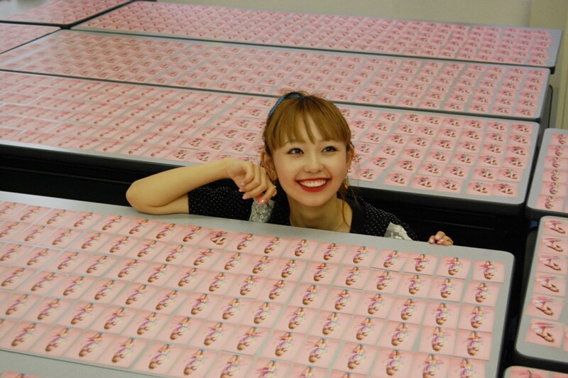 並べられたトレーディングカードを前に微笑むMizca。