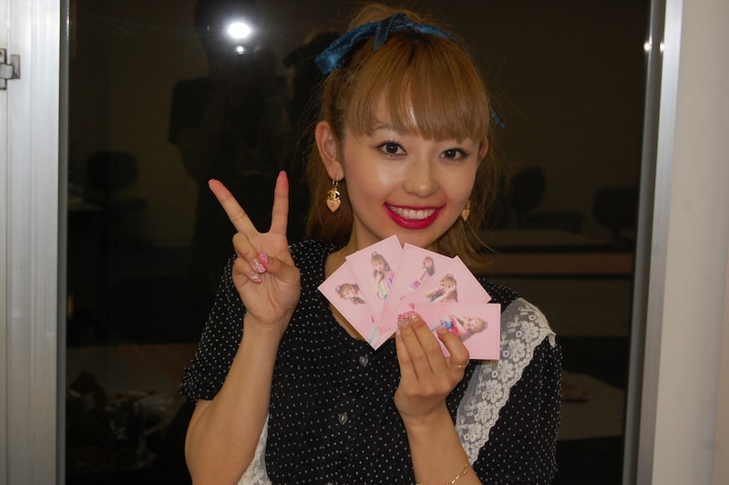 生キス付きトレーディングカードを手にするMizca。トレーディングカードは全部で5種類ある。