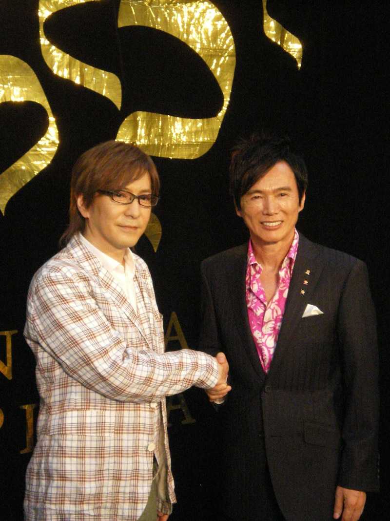 固い握手を交わす小室哲哉（写真左）と森進一（右）、森は7月4日にもラゾーナ川崎ルーファ広場グランドステージにてシングル発売記念イベントを行うほか、6月30日には梅田芸術劇場にて「歌手生活45周年記念 2010 森進一コンサート～はるかなる夢、限りなき道」を開催する。