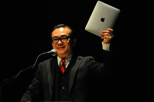 会場でも来場者からの質問メールを募集。茂木淳一は「この電化製品で受信しますよ～！」とiPadを誇らしげに掲げた。