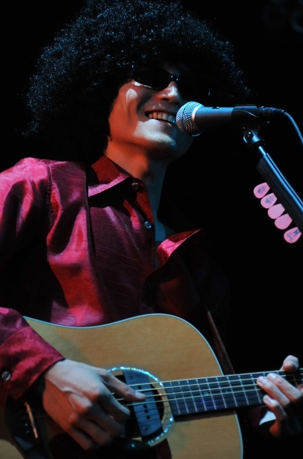 柔和な笑顔の緑上陽水。9ミドのボーカリストと緑上陽水の髪型はほぼ同じに見えるが、スタッフサイドは「あれは別のものを使っています。使い回しではありません」と謎のコメントを発表している。