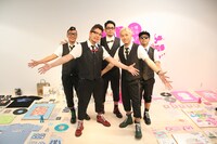 両手を広げて無数の展示品をアピールするRIP SLYME。