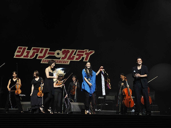 花束を受け取った菅野よう子と、小栗監督にかわいいくす玉をプレゼントする手嶌葵。菅野が手嶌をはじめROY（THE BAWDIES）、石毛輝（the telephones）、曽我部恵一ら個性豊かなボーカリストたちとコラボした劇中曲は、サウンドトラック「SURELY SOMEDAY」として1枚にまとめられ7月7日にリリースされた。