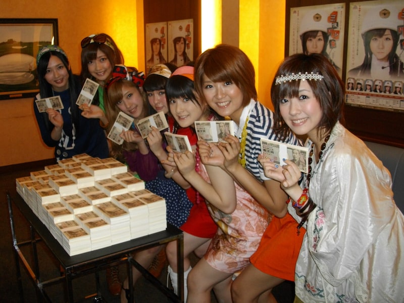 舞台「三億円少女」に先駆けて記者会見に出席したBerryz工房の7人。3億円の札束（フェイク）を前に写真撮影を行った。