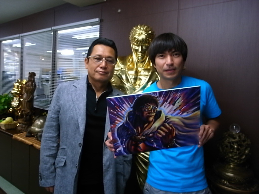 原哲夫（写真左）が描いたイラストを手に、記念撮影をするROCKETMANことふかわりょう（右）。