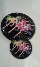 YA-KYIMとgalaxxxyのコラボ缶バッジ2種類。価格は大きいサイズが1000円、小さいサイズが300円。