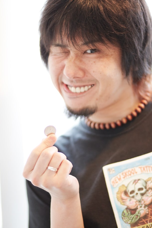 100円(インタビューテキスト販売価格)を握りしめ、夏休みのおこづかいをもらった少年のような笑みを浮かべるKen Yokoyama。