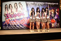 巨大バナーの前に立つ4人。