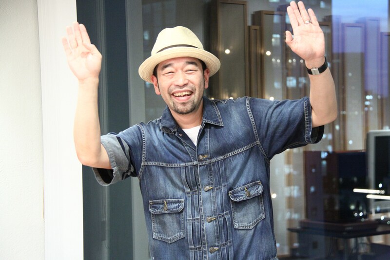 「ほぼ日」会議室を訪れたマッキー。予告ムービーではハイテンションなコメントに加え、なぜかとある落語家の顔マネ芸を連発している。