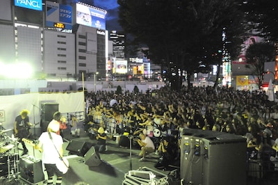 長谷川正（B/ステージ上右端）は曲が終わるたびに、観覧エリアにピックを投げるファンサービスを披露。