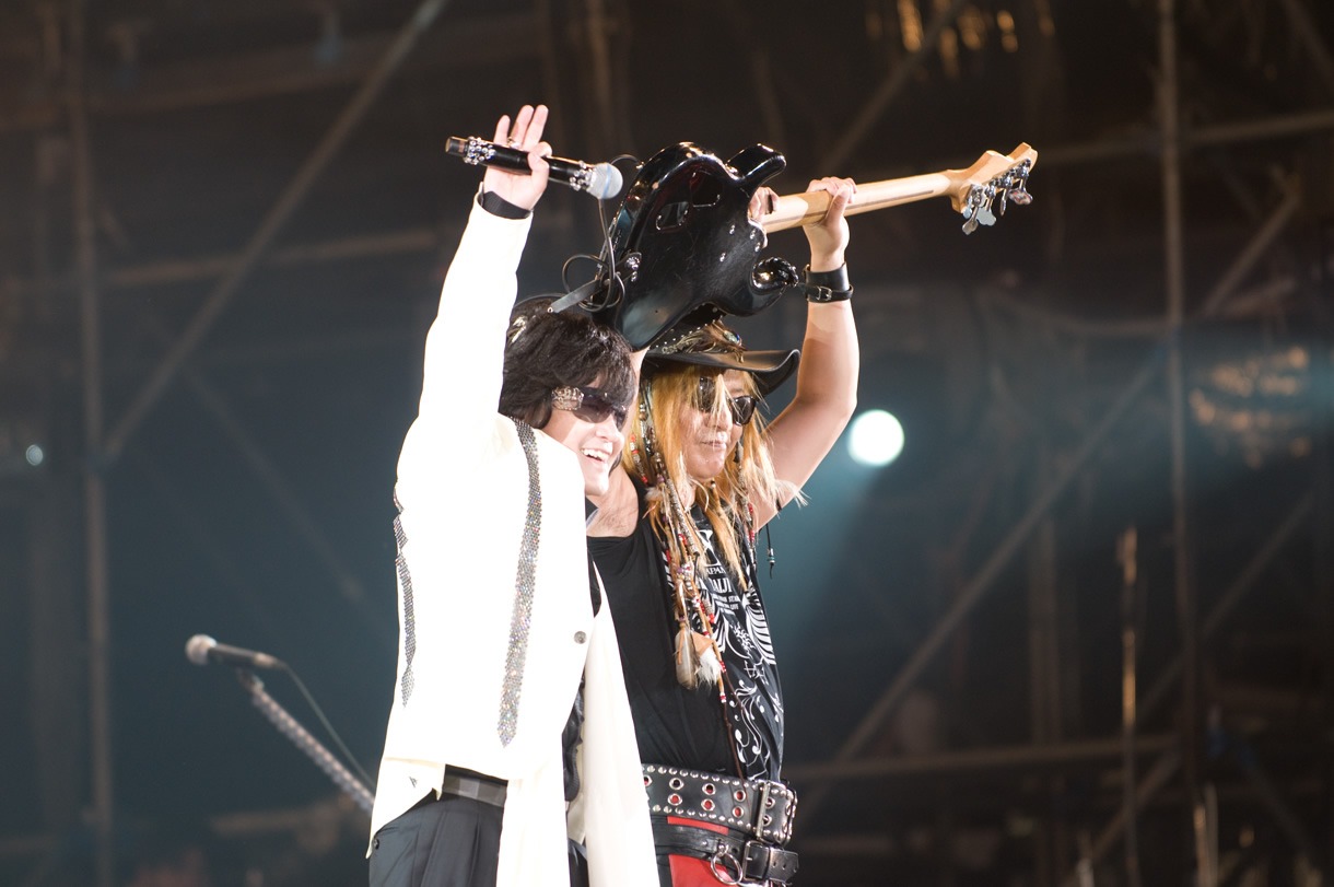 旧友同士で肩を組み合うToshI（写真左）とTAIJI（写真右）。