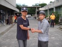 ガッチリ男同士の握手を交わす堤幸彦（写真左）とSunya（右）。