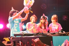 COSMETICSの3人から花束を渡され、笑顔を見せるふかわりょう。