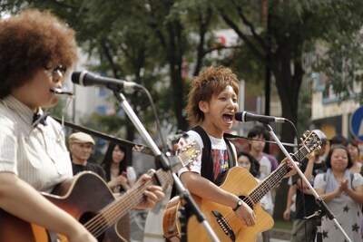 晴天のもと、ギターをかき鳴らし、熱唱するひいらぎの2人。