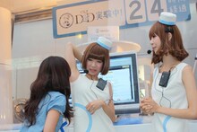 通行人の女性からワキのニオイをチェックされるレナ（写真左）と、その様子を見守るリサ（写真右）。