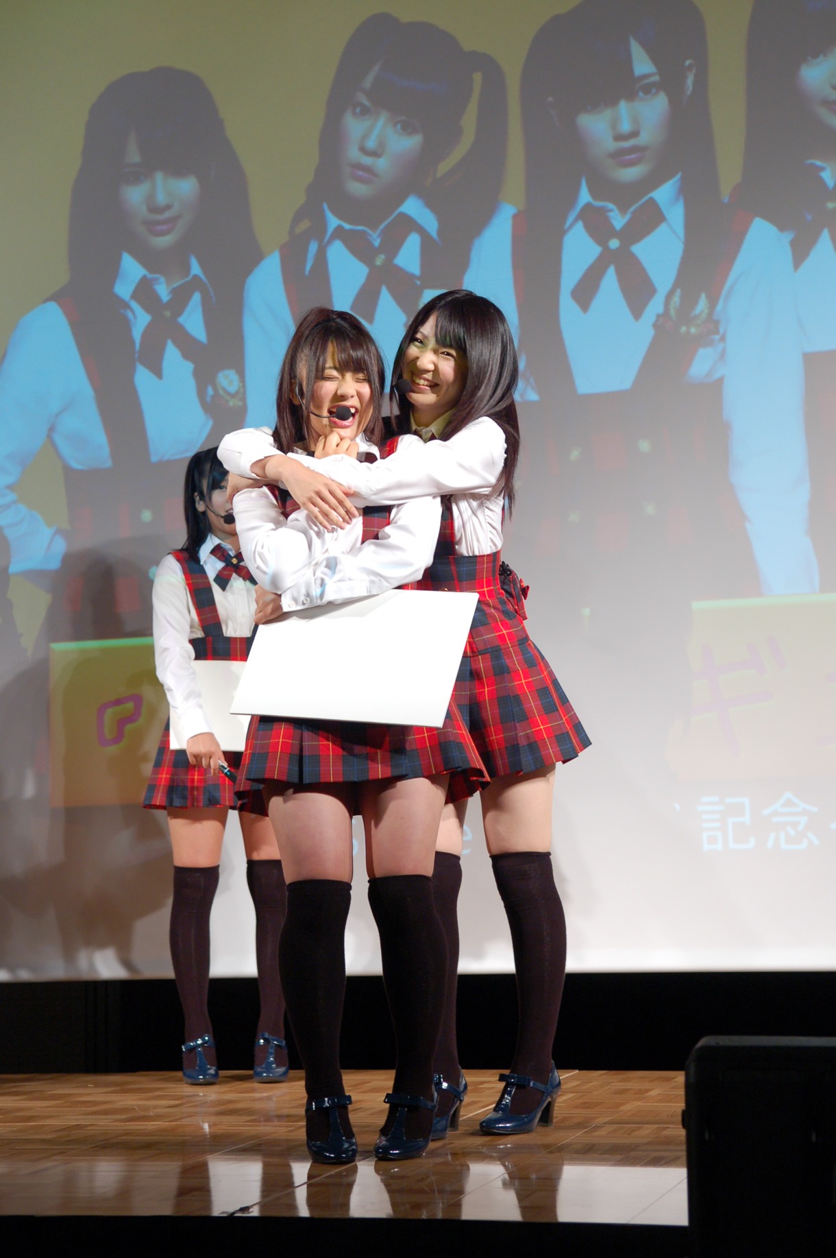 「ギュッとされてドキドキするシチュエーション」を実演し、思わずニヤニヤしてしまう平嶋夏海（写真左）と菊地あやか（右）。