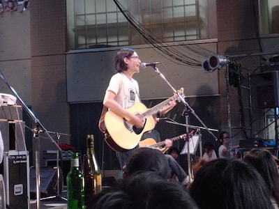 藝大生の手作りという「藝祭」Tシャツを着用してステージに立つミドリカワ。主催者への気配りとすり寄りは忘れない。