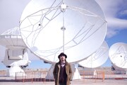 「ALMA」のビデオクリップ撮影のためにチリを訪れた大木伸夫。後ろはパラボラアンテナ。