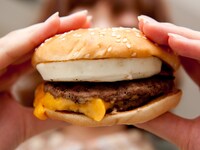 写真はチーズたまごダブルマック。2枚のパティとたまご、チーズ、ベーコンがあふれんばかりにサンドされている（商品は撮影後スタッフがおいしくいただきました）。