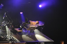 ピアノの上に倒れ込むYOSHIKI。