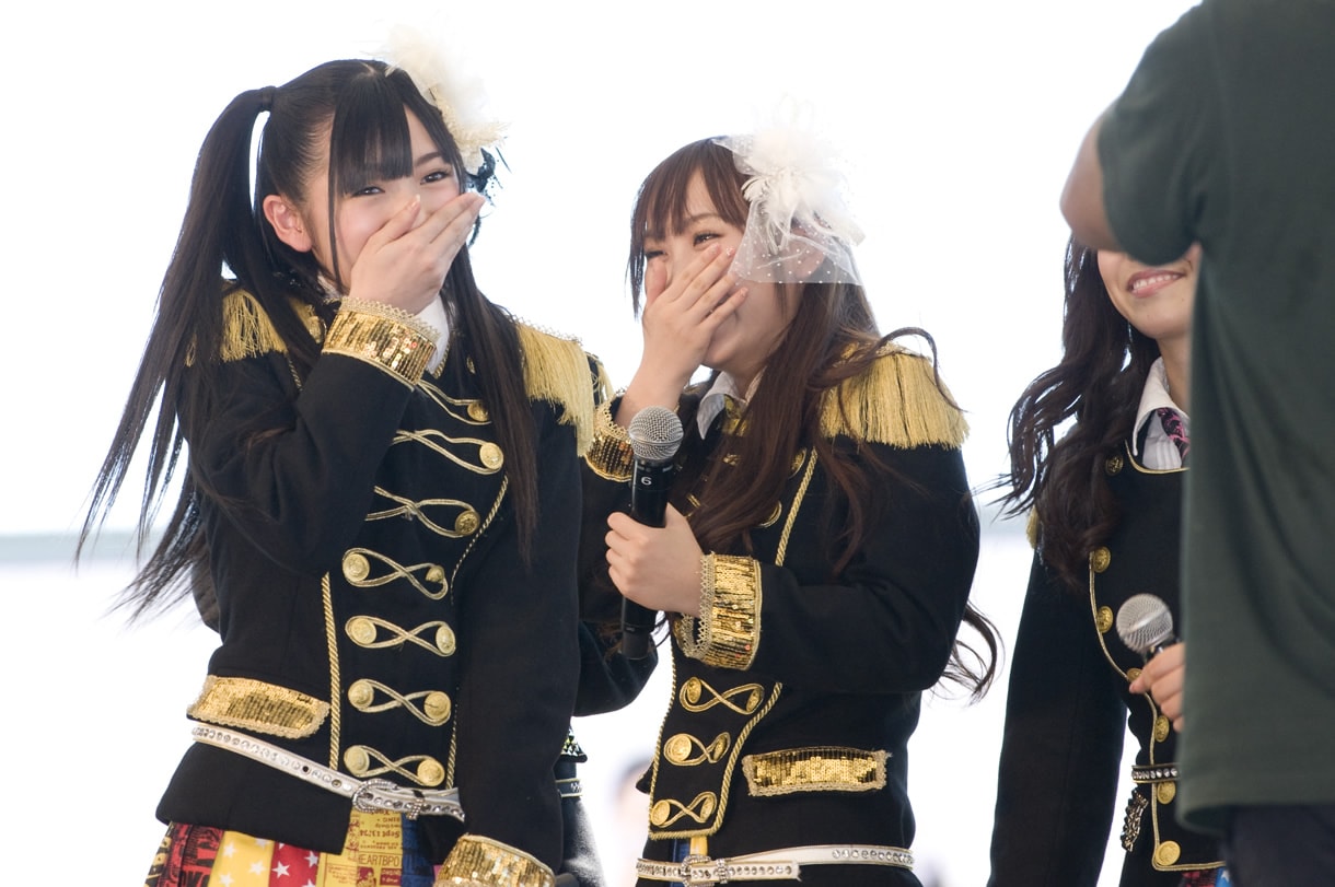 渡辺麻友（写真左）はキス顔を見せた後、思わず恥ずかしくなって手で顔