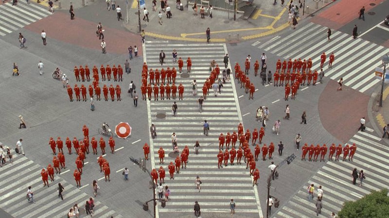 写真は「出没篇」より。スクランブル交差点でポッキー化した民衆による人文字「エビバデポッキー」。