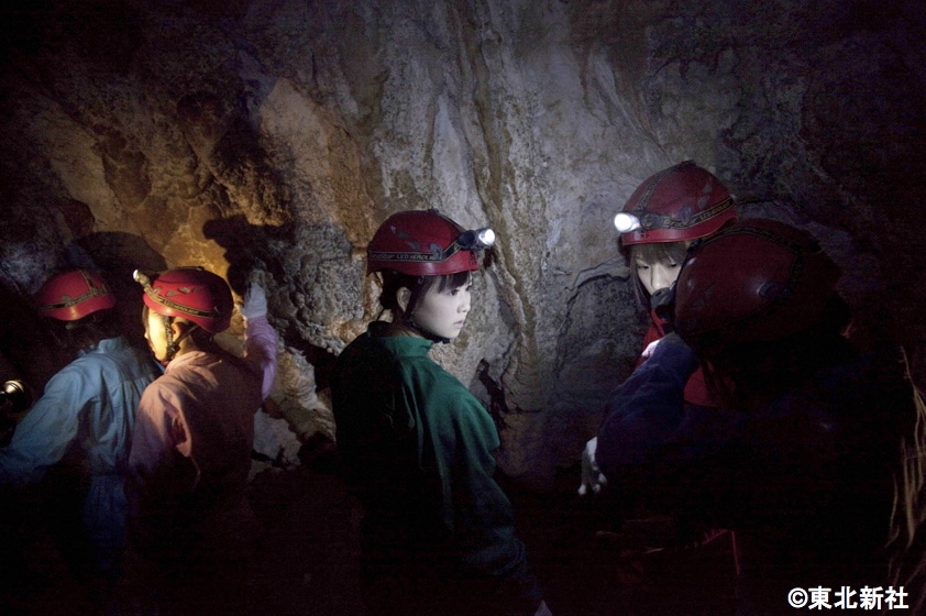 暗闇の中、ヘッドらライトの明かりを頼りに洞窟を進むメンバー。