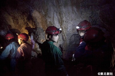 暗闇の中、ヘッドらライトの明かりを頼りに洞窟を進むメンバー。