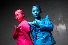 衣装の色に合わせて、肌や髪を赤＆青に染めた松井玲奈（写真左）と松井珠理奈（右）。