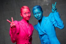 撮影の合間に、カメラに向けてピースサインを出す松井玲奈（写真左／赤）と松井珠理奈（右／青）。