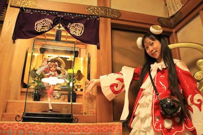 奉納されたとろ弁天像。キャラクターの元となったイラストはとろ美（写真右）によるもの。