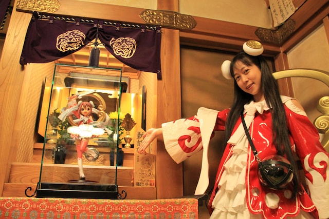 奉納されたとろ弁天像。キャラクターの元となったイラストはとろ美（写真右）によるもの。