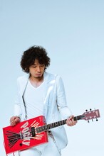 ポッキーギターを構える斉藤和義。
